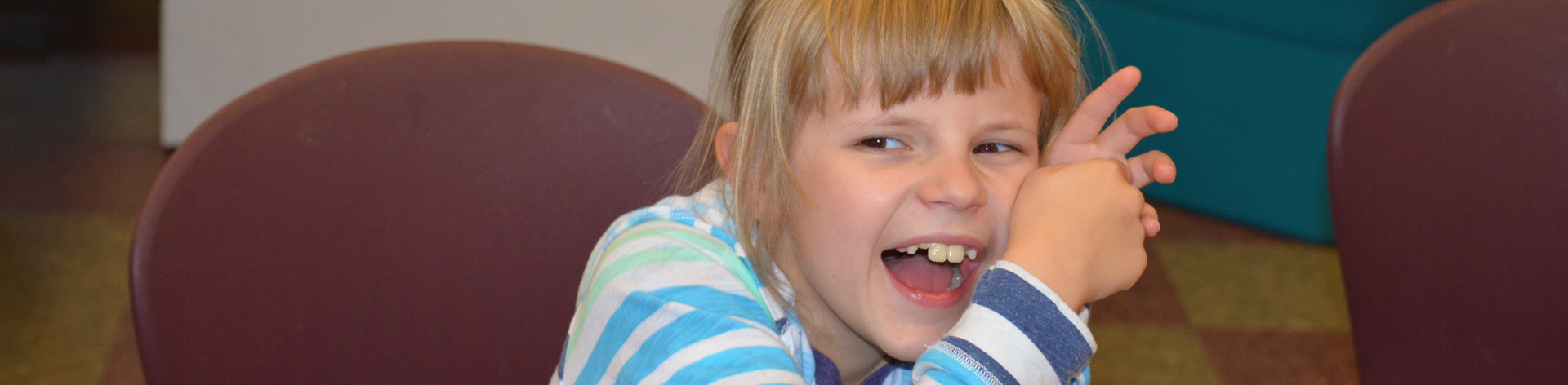 A young blind girl smiles widely.